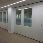 Sala dividida con tabique móvil mixto de madera y cristal